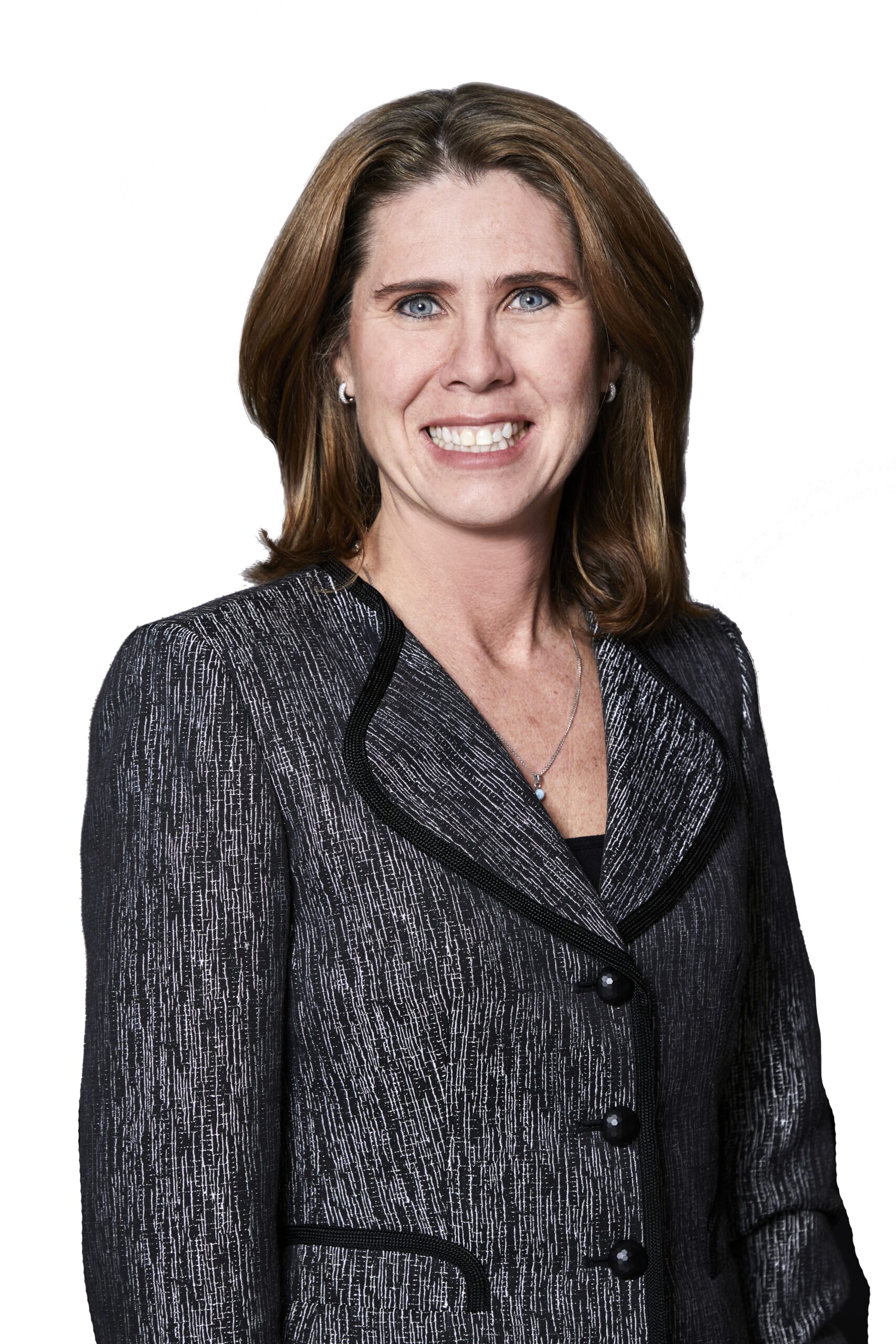 Laurie L. Newmark, a smiling woman with shoulder-length brown hair, wears a dark textured blazer over a black top as she faces the camera against a white background.