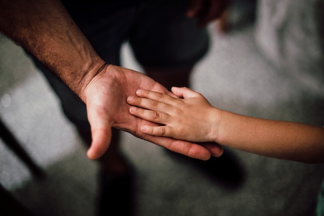 child's hand in larger hand
