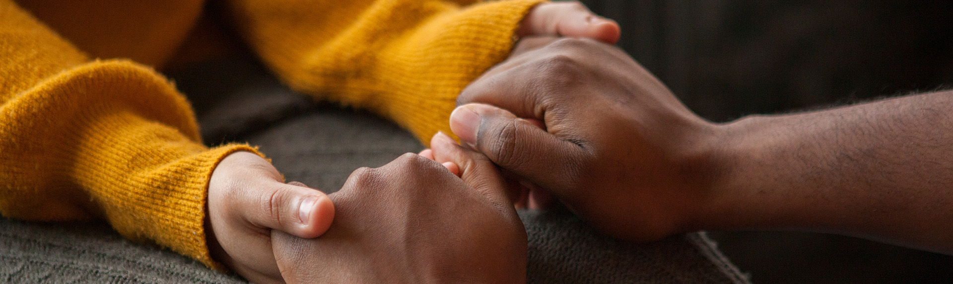 Man holding hands of his child to comfort - Child Custody Attorney concept image