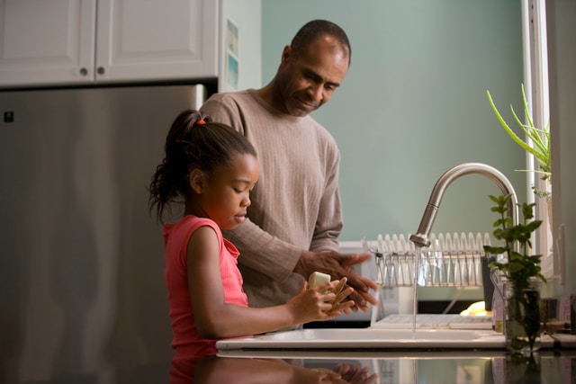 father with daughter doing dishes