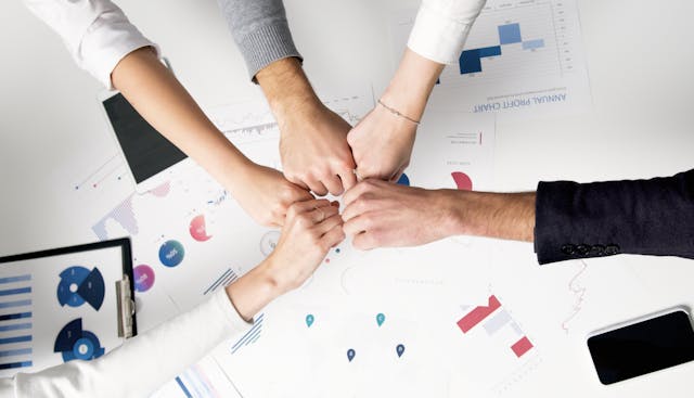 multiple hands meeting in middle